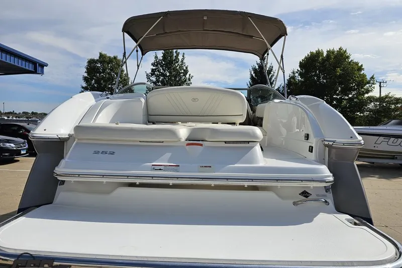 Slide: The Image of 2007 Cobalt 252 boat with white seating and canopy, parked outdoors. - 30