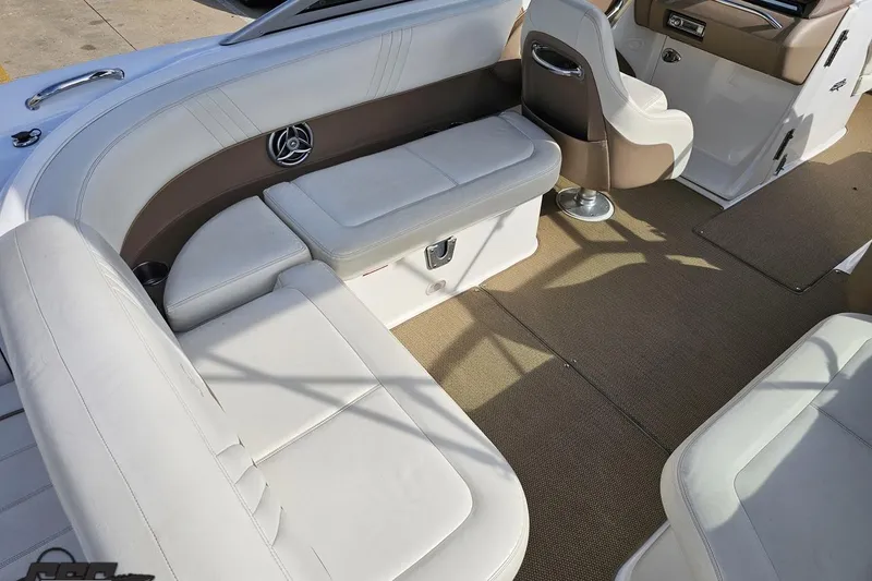 Slide: The Image of 2007 Cobalt 252 boat interior with white leather seating and beige carpet flooring. - 46