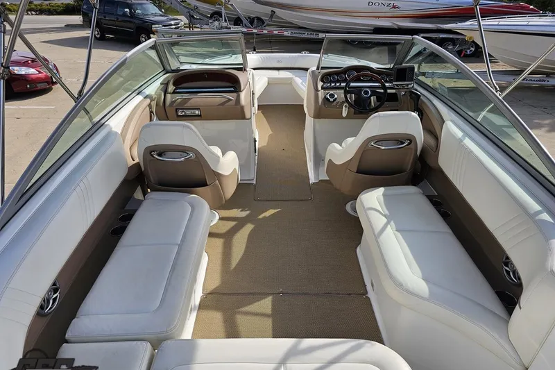 Slide: The Image of 2007 Cobalt 252 boat interior with white and beige seating, steering wheel, and dashboard. - 48