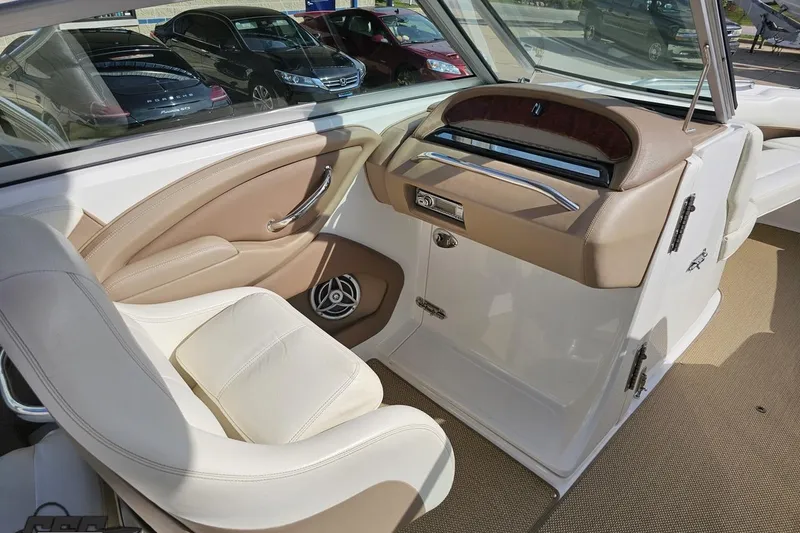 Slide: The Image of 2007 Cobalt 252 boat interior with beige and white seating, dashboard, and speaker. - 51