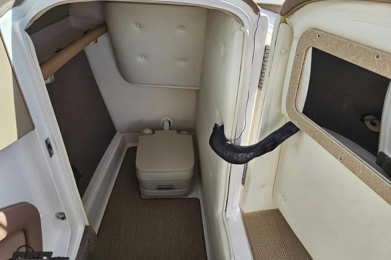 Slide: The Image of 2007 Cobalt 252 boat interior with compact toilet and storage area. - 56