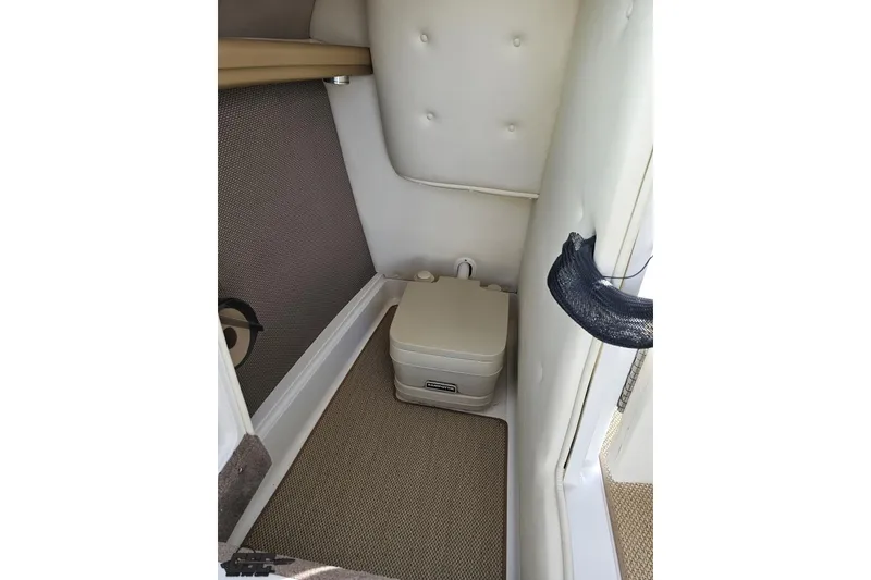 Slide: The Image of 2007 Cobalt 252 boat interior with portable toilet and cushioned walls. - 57