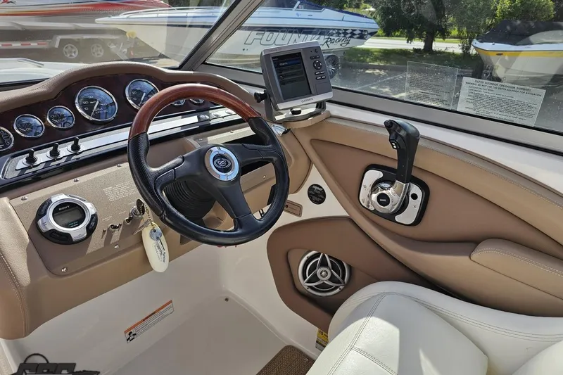 Slide: The Image of 2007 Cobalt 252 boat dashboard with steering wheel, gauges, and navigation system. - 62