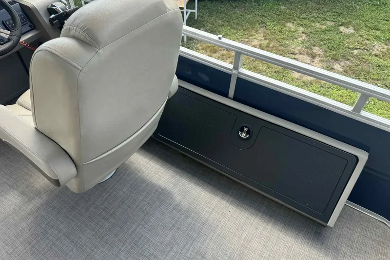 Slide: The Image of 2024 Sun Tracker Fishin' Barge 22 DLX interior with seating and storage compartment. - 3