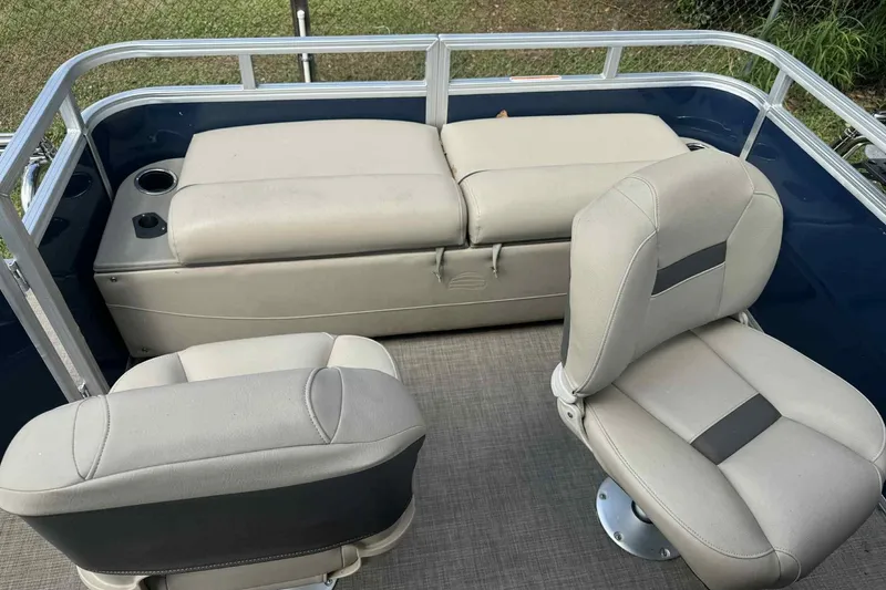 Slide: The Image of 2024 Sun Tracker Fishin' Barge 22 DLX interior with comfortable seating and cup holders. - 4