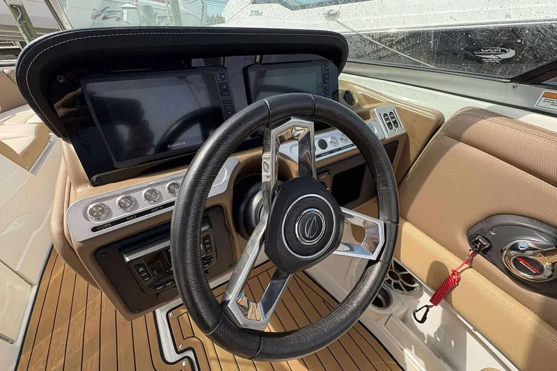 Slide: The Image of 2023 Crownline 280 XSS boat dashboard with steering wheel and navigation controls. - 10