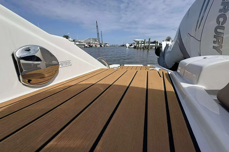 Slide: The Image of 2023 Crownline 280 XSS boat deck with Mercury engine, docked by the water. - 20