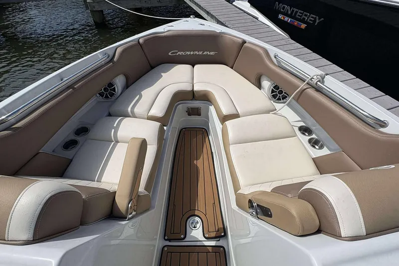 Slide: The Image of 2023 Crownline 280 XSS boat interior with beige seating and wood accents. - 7