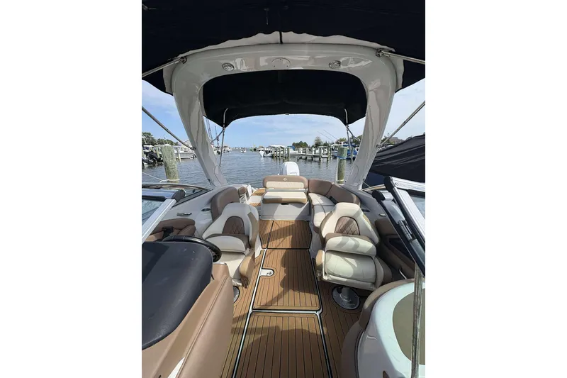 Slide: The Image of 2023 Crownline 280 XSS boat interior with luxurious seating and wood flooring. - 9