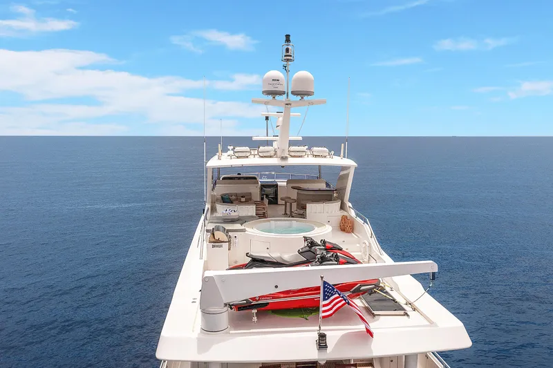 Slide: The Image of Luxury 2009 Hargrave Raised Pilothouse yacht on open sea, featuring spacious deck and American flag. - 28