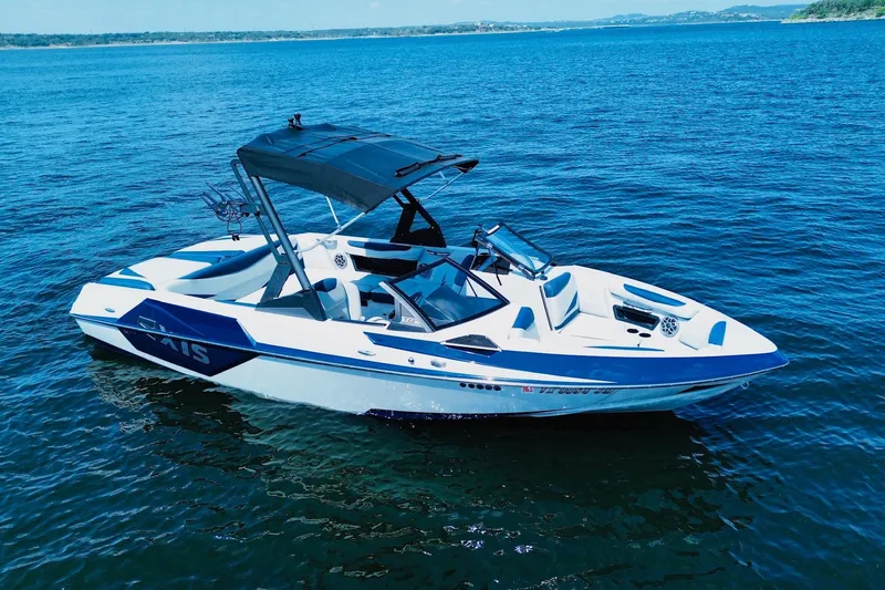 Slide: The Image of 2021 Axis T22 boat on calm blue water, featuring sleek design and canopy. - 1