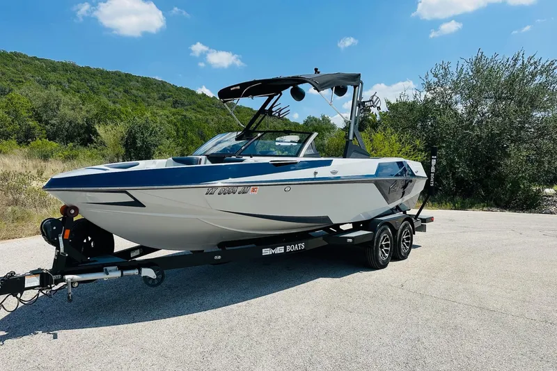 Slide: The Image of 2021 Axis T22 boat on trailer, parked outdoors with scenic background. - 10