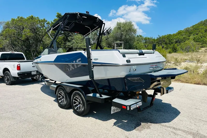Slide: The Image of 2021 Axis T22 boat on trailer, parked outdoors with a truck nearby. - 13