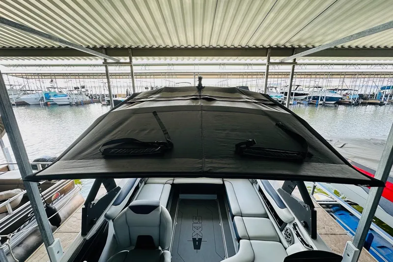 Slide: The Image of 2021 Axis T22 boat under a covered dock, showcasing interior and canopy. - 24