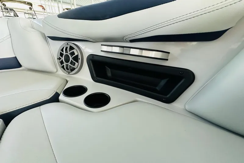 Slide: The Image of 2021 Axis T22 boat interior with speaker, cup holders, and sleek white upholstery. - 25