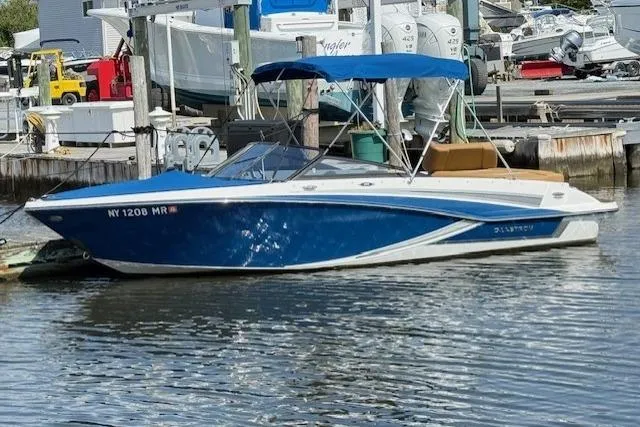 The Image of 2019 Glastron GT 205 boat with blue hull docked at marina. - 0