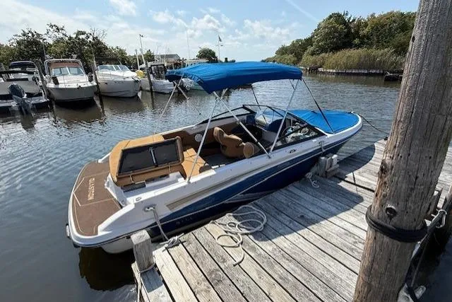 Slide: The Image of 2019 Glastron GT 205 boat docked at a marina with blue canopy. - 3