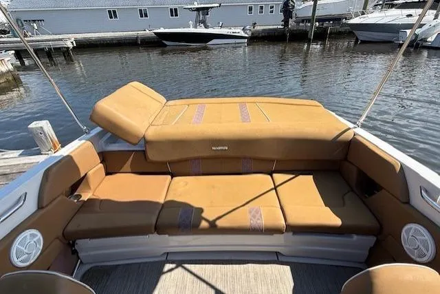 Slide: The Image of 2019 Glastron GT 205 boat with tan seating, docked at a marina. - 6