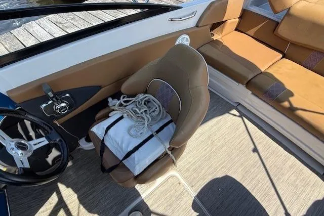 Slide: The Image of 2019 Glastron GT 205 boat interior with tan seating and steering wheel. - 8