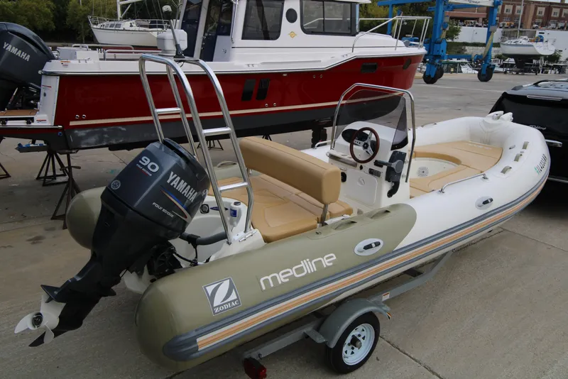 The Image of 2011 Zodiac Medline 550 NEO boat docked in a marina with urban buildings in the background. - 0