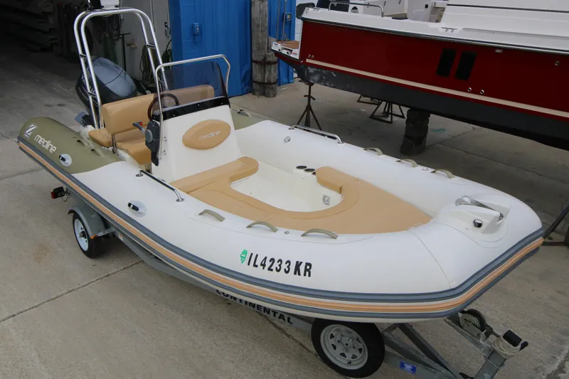 Slide: The Image of 2011 Zodiac Medline 550 NEO boat with Yamaha 90 engine docked at marina. - 2