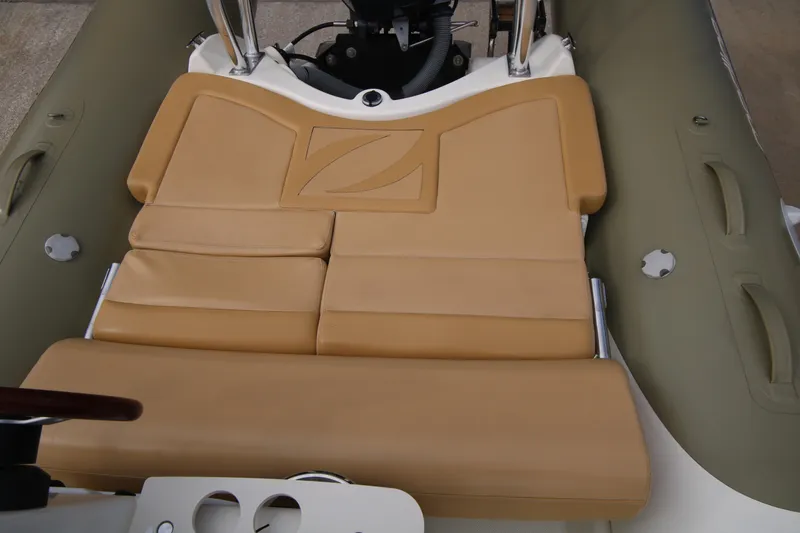Slide: The Image of 2011 Zodiac Medline 550 NEO boat storage compartment with beige seating. - 29