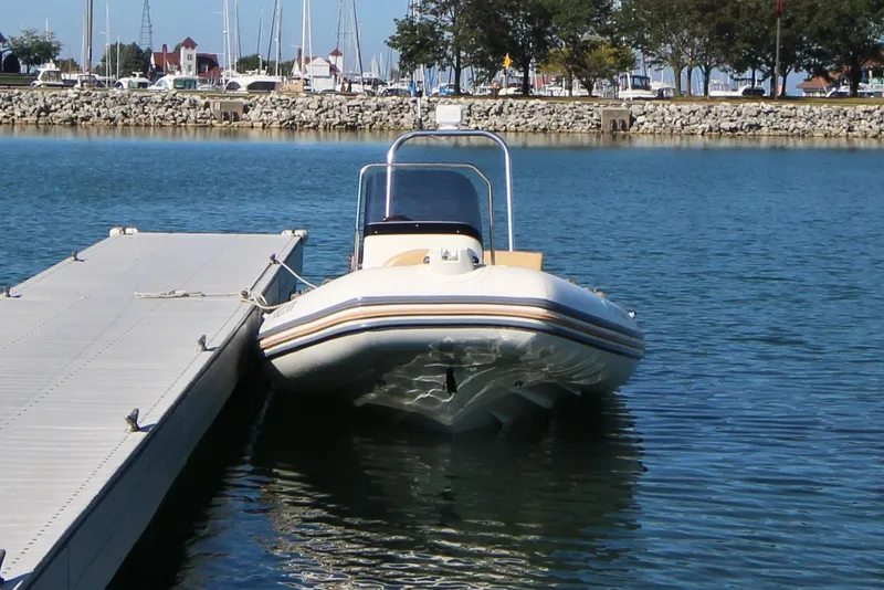 Slide: The Image of 2011 Zodiac Medline 550 NEO boat docked at a marina with calm waters. - 43