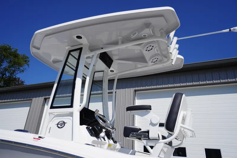 Slide: The Image of 2026 Tidewater 220 LXF boat helm with T-top and seating, against blue sky. - 3