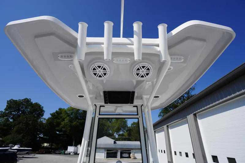 Slide: The Image of 2026 Tidewater 220 LXF boat roof with rod holders and speakers, under clear blue sky. - 51