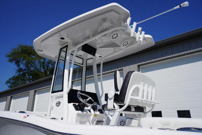 Slide: The Image of 2026 Tidewater 220 LXF boat with T-top and dual seating, parked outdoors. - 55
