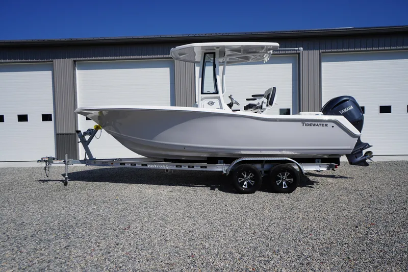 Slide: The Image of 2026 Tidewater 220 LXF boat on trailer, parked outside a garage. - 68