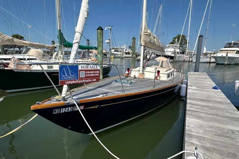 Slide: The Image of 2006 Morris M36 sailboat for sale at marina dock, featuring sleek design and wooden deck. - 12