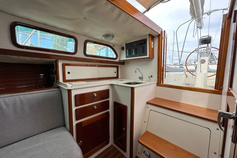 Slide: The Image of Interior of a 2006 Morris M36 sailboat with wooden cabinetry and compact kitchen area. - 19