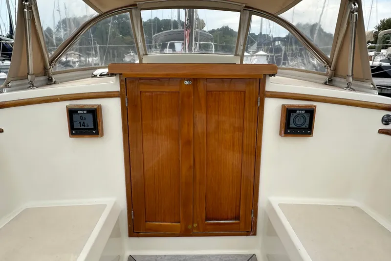 Slide: The Image of Interior view of a 2006 Morris M36 sailboat cockpit with wooden doors and navigation instruments. - 23