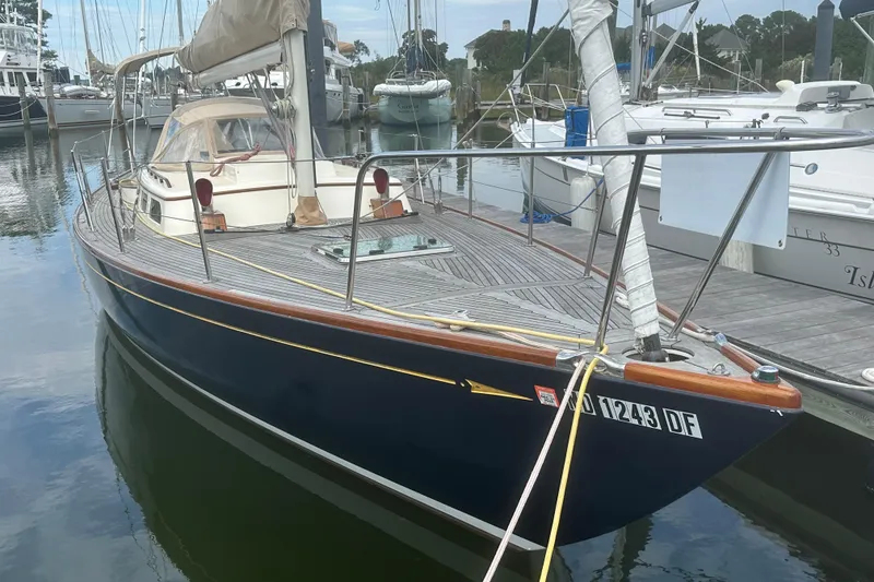 Slide: The Image of 2006 Morris M36 sailboat docked in a marina, featuring a sleek design and wooden deck. - 28