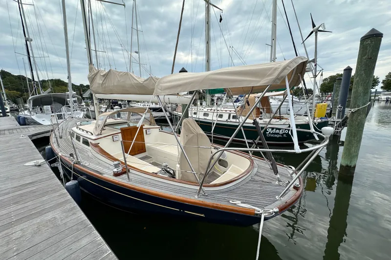Slide: The Image of Sailboat docked at marina, Morris M36, 2006 model, with beige canopy and wooden deck. - 5