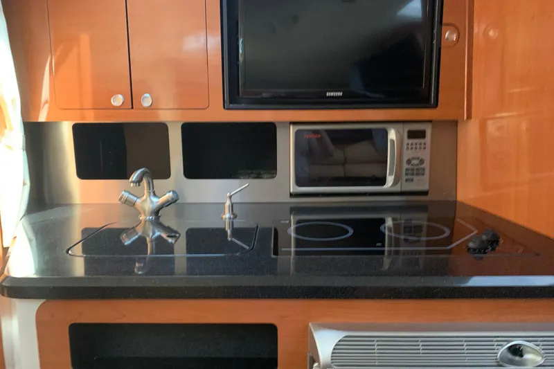 Slide: The Image of 2008 Century 3200 Offshore kitchen with stove, microwave, and sink. - 14