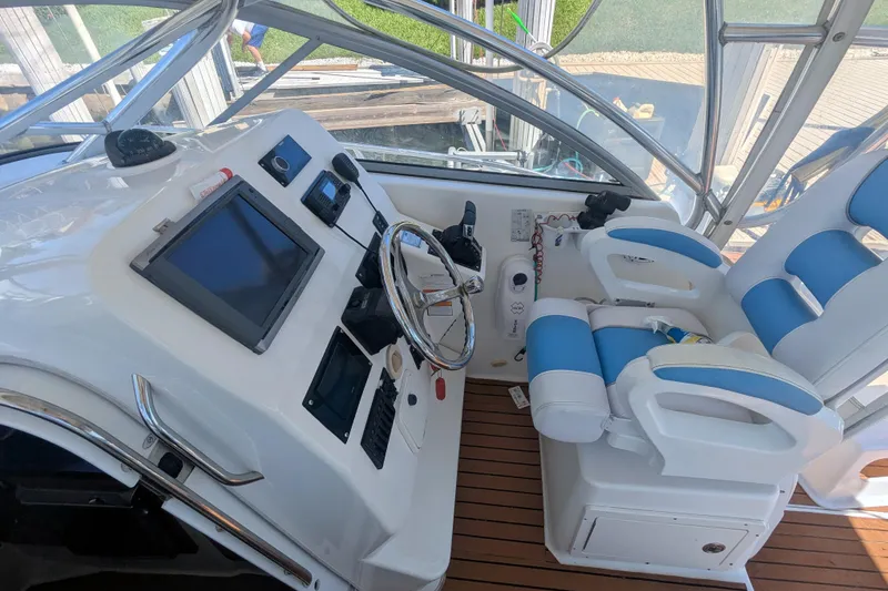 Slide: The Image of 2008 Century 3200 Offshore boat cockpit with steering wheel, navigation equipment, and blue cushioned seats. - 8