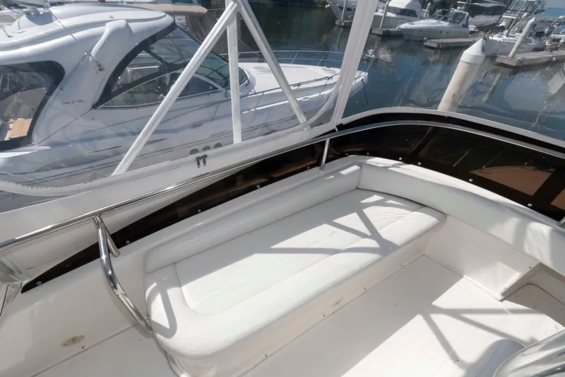 Slide: The Image of 2000 Silverton 37 Convertible yacht interior with white seating at marina. - 11