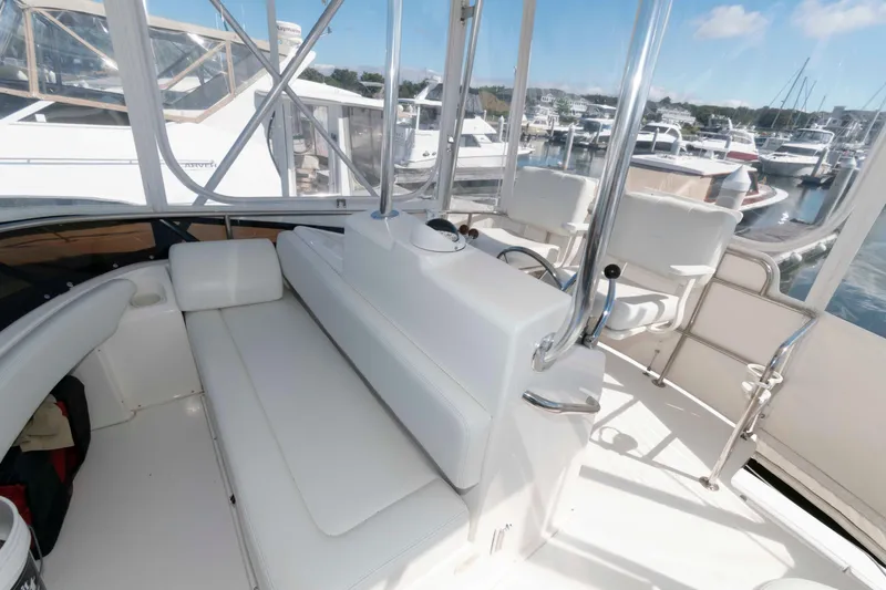 Slide: The Image of Interior view of 2000 Silverton 37 Convertible yacht with white seating and marina backdrop. - 12
