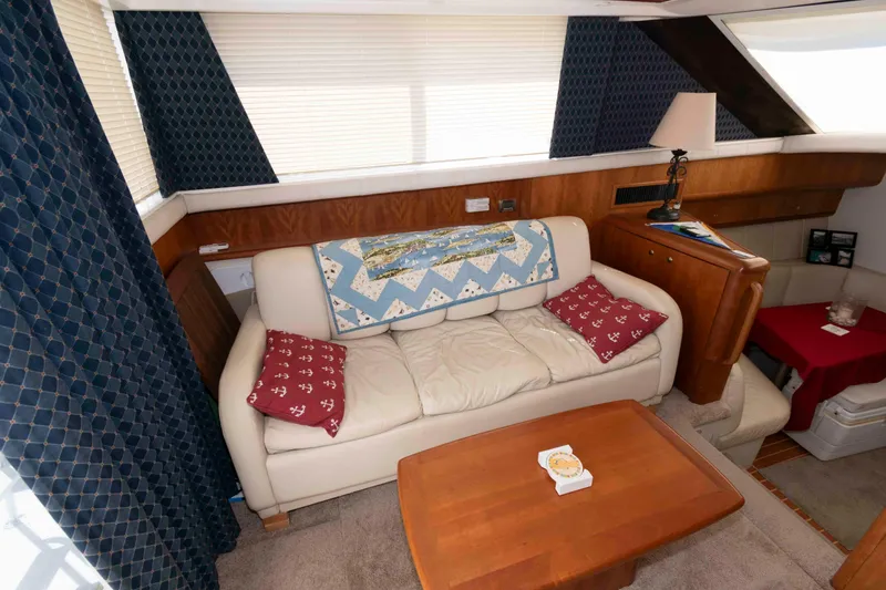 Slide: The Image of Interior of 2000 Silverton 37 Convertible yacht with cozy seating and nautical decor. - 15