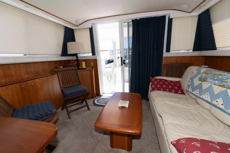 Slide: The Image of Interior of 2000 Silverton 37 Convertible yacht with cozy seating and wooden furnishings. - 17