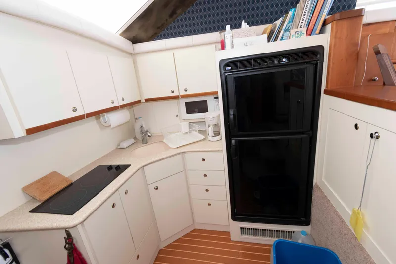 Slide: The Image of Kitchen area of a 2000 Silverton 37 Convertible yacht with modern appliances. - 19