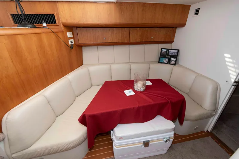 Slide: The Image of Interior of 2000 Silverton 37 Convertible yacht with cozy seating and red tablecloth. - 20