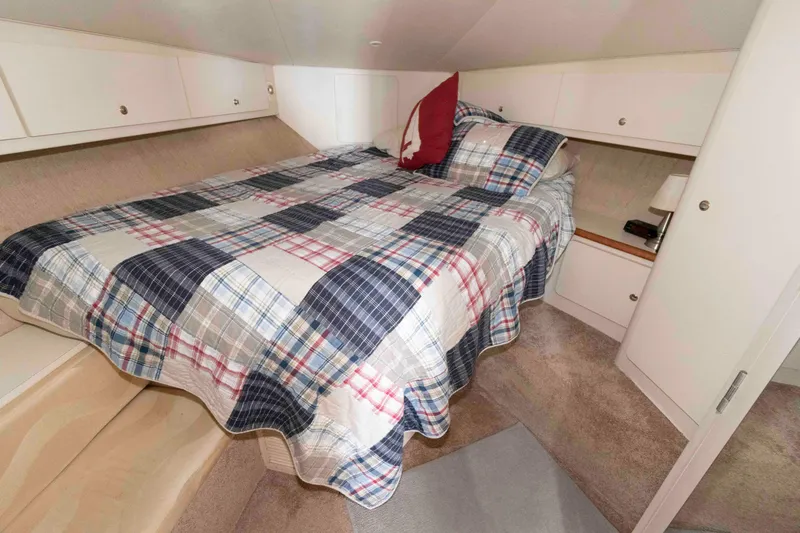 Slide: The Image of Cozy bedroom in 2000 Silverton 37 Convertible yacht with plaid bedding and storage cabinets. - 21
