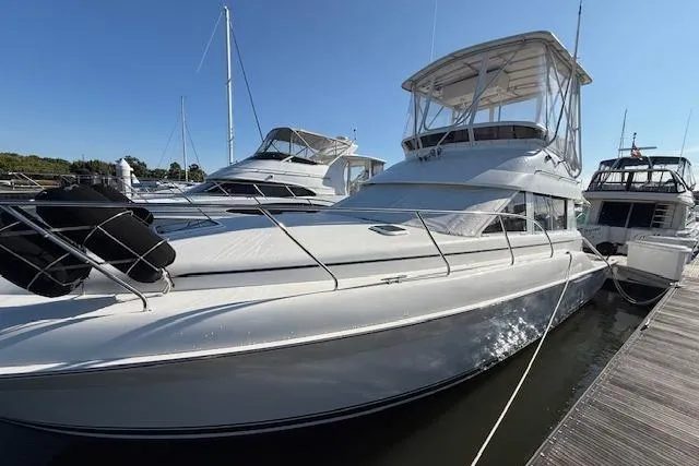 Slide: The Image of 2000 Silverton 37 Convertible yacht docked at marina, surrounded by other boats. - 3