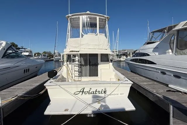 Slide: The Image of 2000 Silverton 37 Convertible yacht docked at marina under clear blue sky. - 4