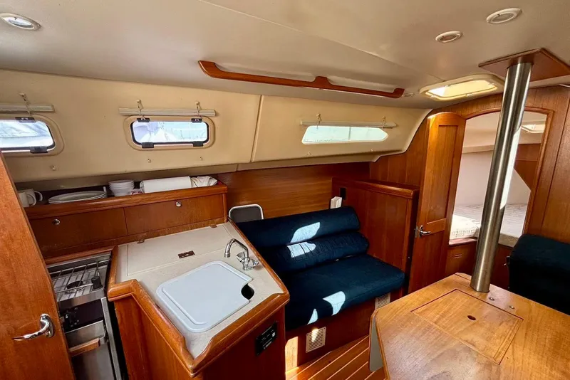 Slide: The Image of Interior of 2002 Hunter 306 sailboat with cozy seating and compact kitchen area. - 7