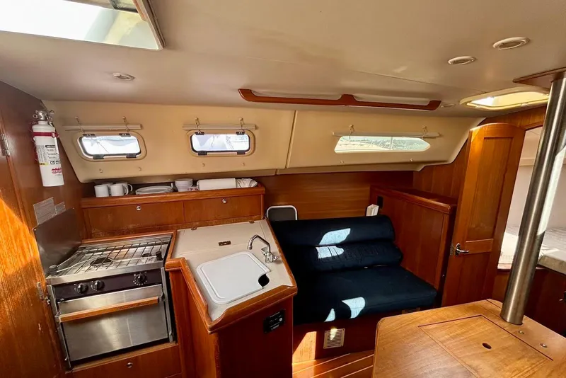 Slide: The Image of Interior of 2002 Hunter 306 sailboat with kitchen and seating area. - 8