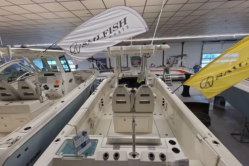 Slide: The Image of 2026 Sailfish 252 CC boat displayed indoors with branded flags. - 3